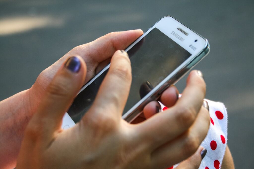 Mano sosteniendo un smartphone Android antiguo con WhatsApp