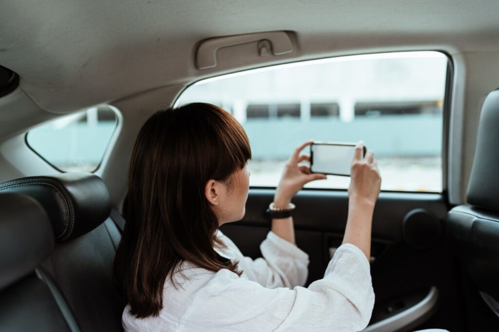 Persona usando el móvil en el asiento del coche durante un trayecto